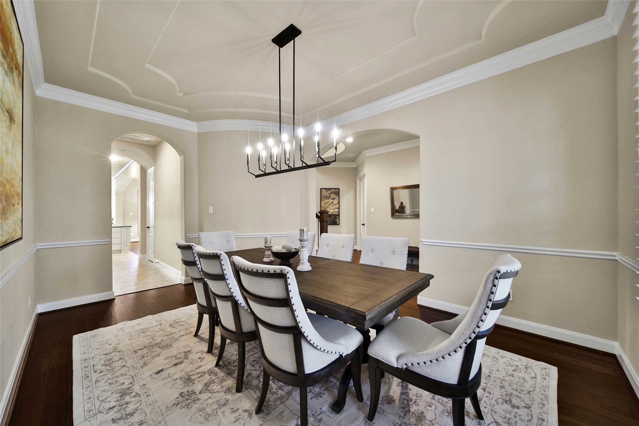 Enjoy intimate dinners and special gatherings in this spacious dining room, where a beautiful tray ceiling,crown molding,  and designer lighting with a dimmer switch create the perfect ambiance for any occasion.