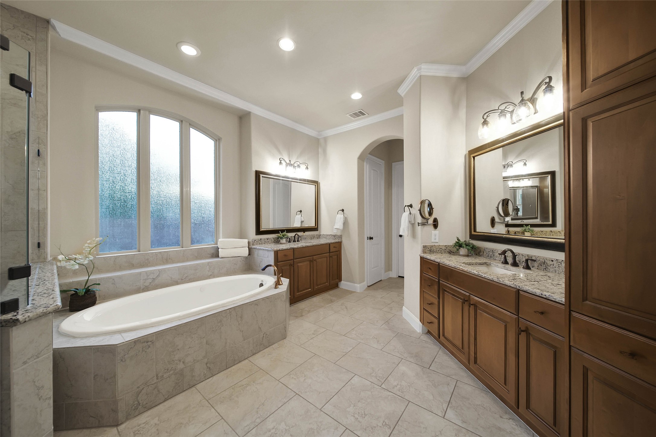 Neutral colors and natural materials add sublte stye to the primary bath complete with dual vanities and closets.