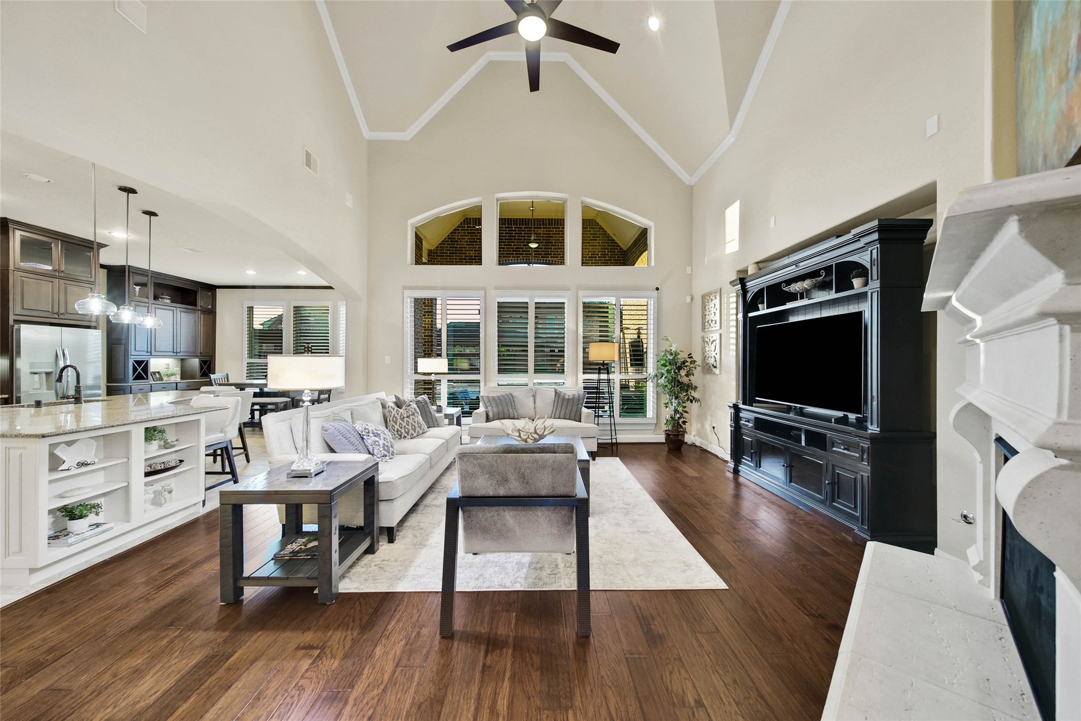 The inviting living room serves as the perfect gathering spot, with serene backyard views creating a peaceful backdrop for relaxing or entertaining. A convenient in-floor outlet provides easy access to power without compromising furniture placement or the rooms clean, uncluttered look.