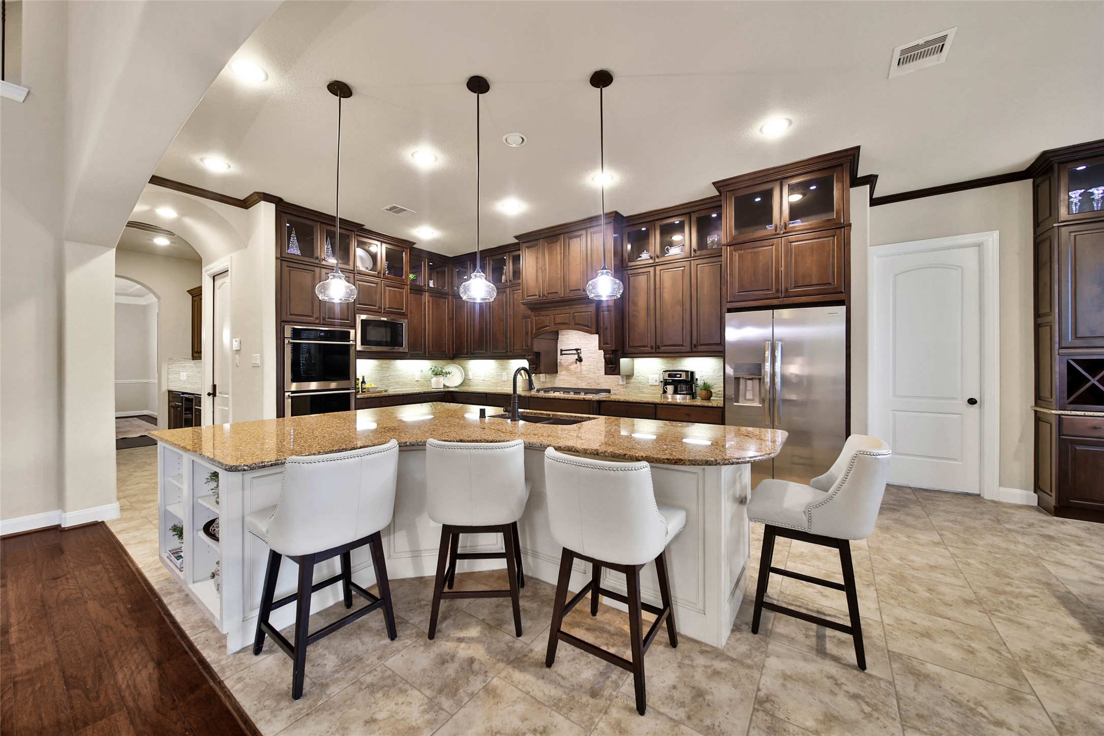 Style meets function in this beautifully appointed kitchen that is sure to impress any chef! Abundant upgraded cabinetry provides exceptional storage, including elegant glass-front upper cabinets with puck lighting, while expansive countertops offer plenty of space for meal prep.