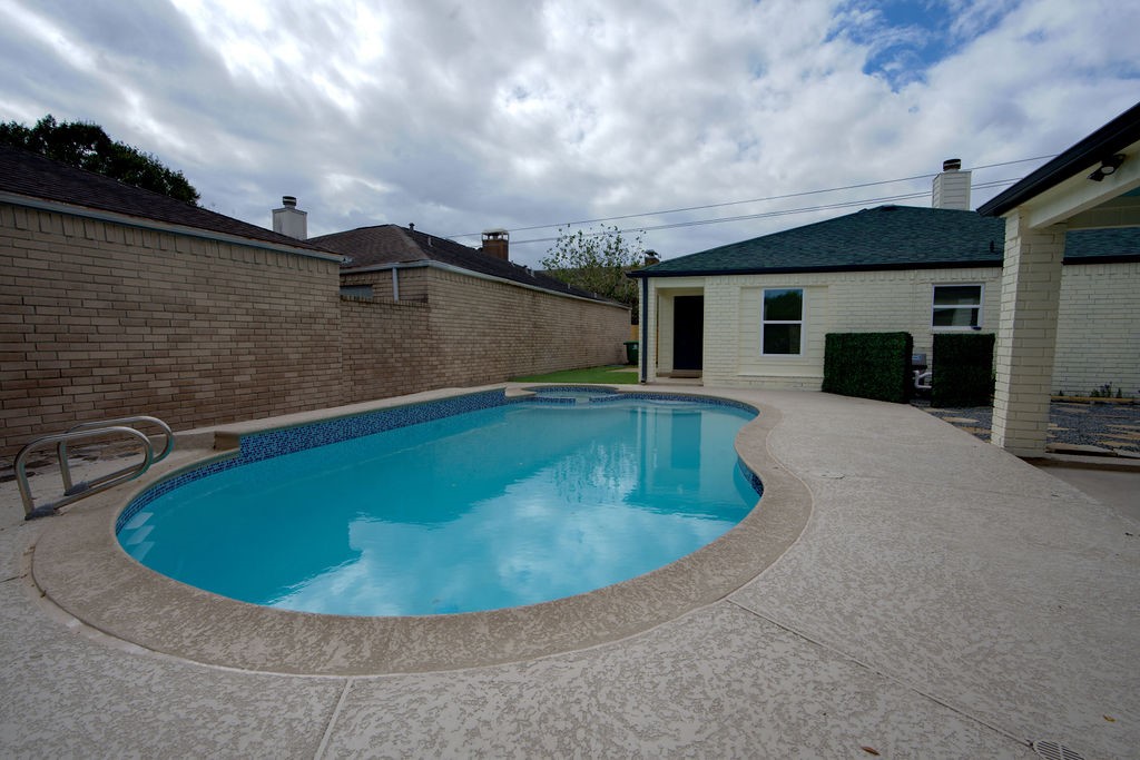 Enjoy a refreshing dip in this inviting backyard pool, surrounded by a spacious deck perfect for entertaining or relaxing.