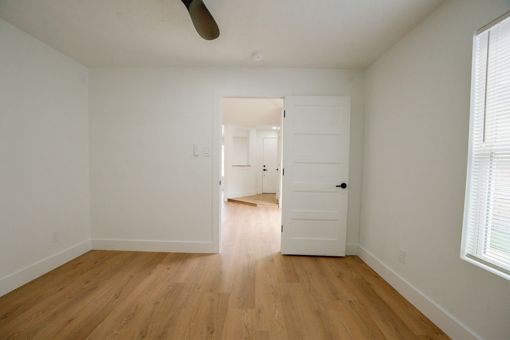 Bright and airy room featuring sleek wood style flooring and modern ceiling fan.