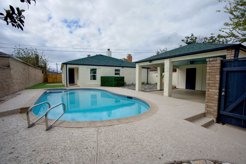 The backyard oasis features a sparkling pool surrounded by a spacious patio, perfect for relaxing and entertaining.