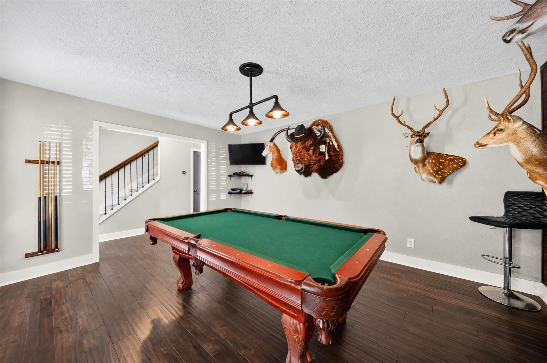 Billiard Room: Impressive billiard room offering ample space for recreation and entertaining, with rich wood-look flooring and convenient access to the main living areas.