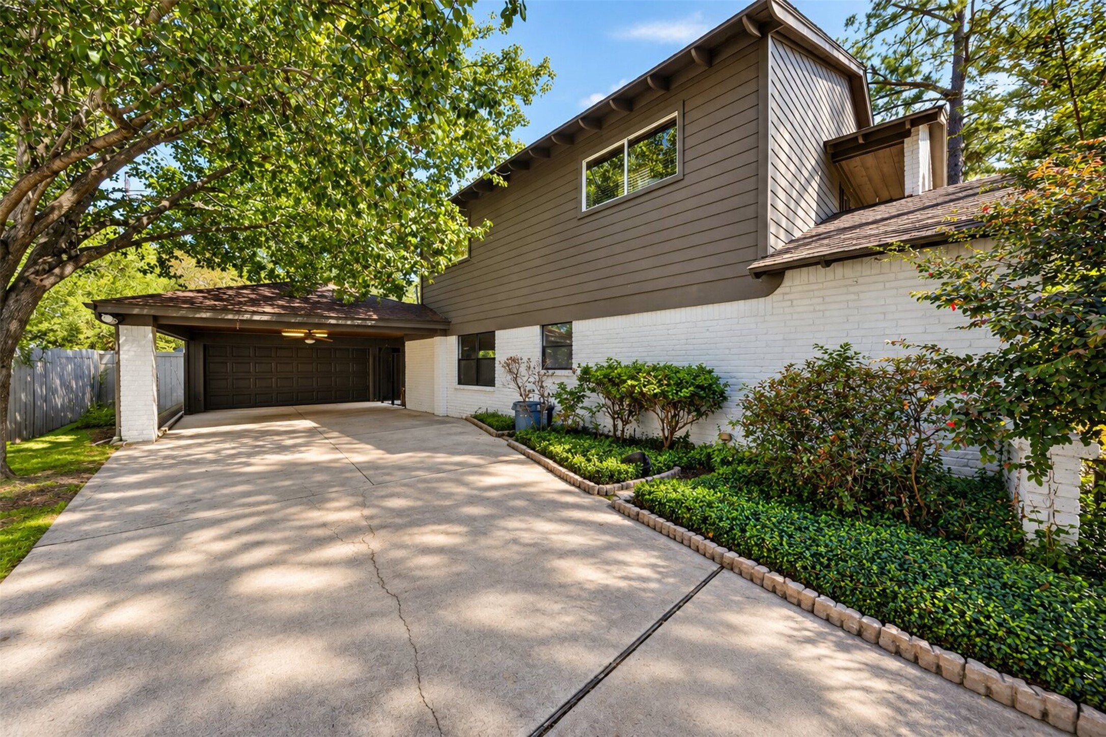 Driveway & Garage: Extended driveway leading to the detached two-car garage, surrounded by mature trees and beautifully maintained landscaping.