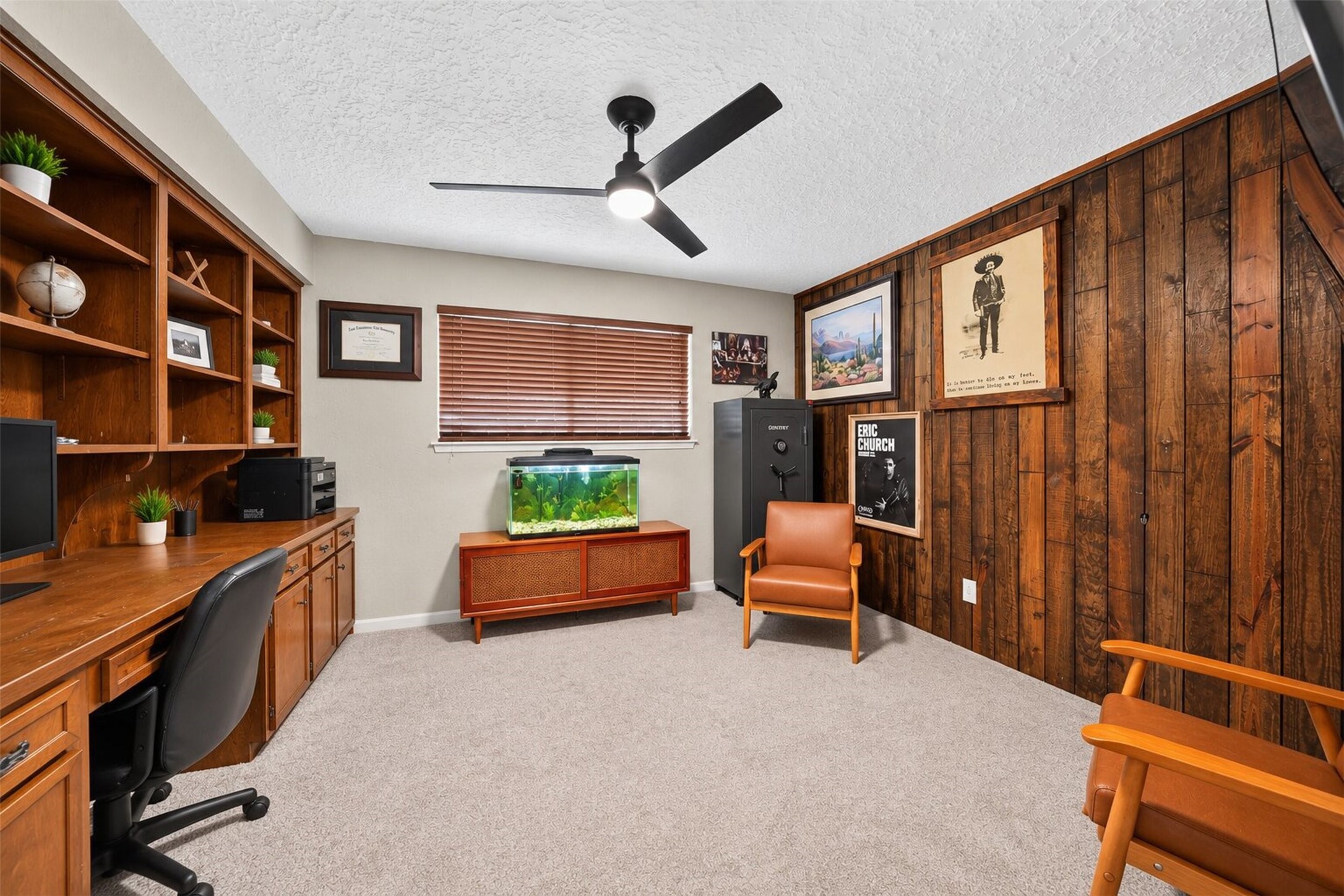 Home Office: Dedicated home office featuring extensive built-in wood cabinetry, shelving, and workspace, complemented by warm wood accents.