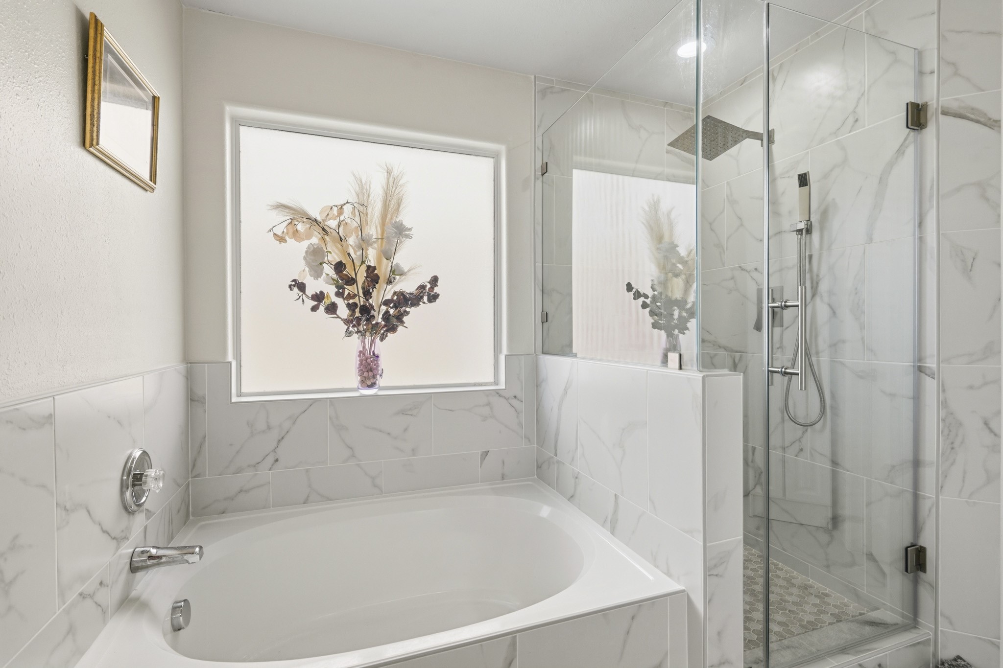 Unwind in the remodeled primary bathroom, complete with a soaking tub and separate glass-enclosed shower.