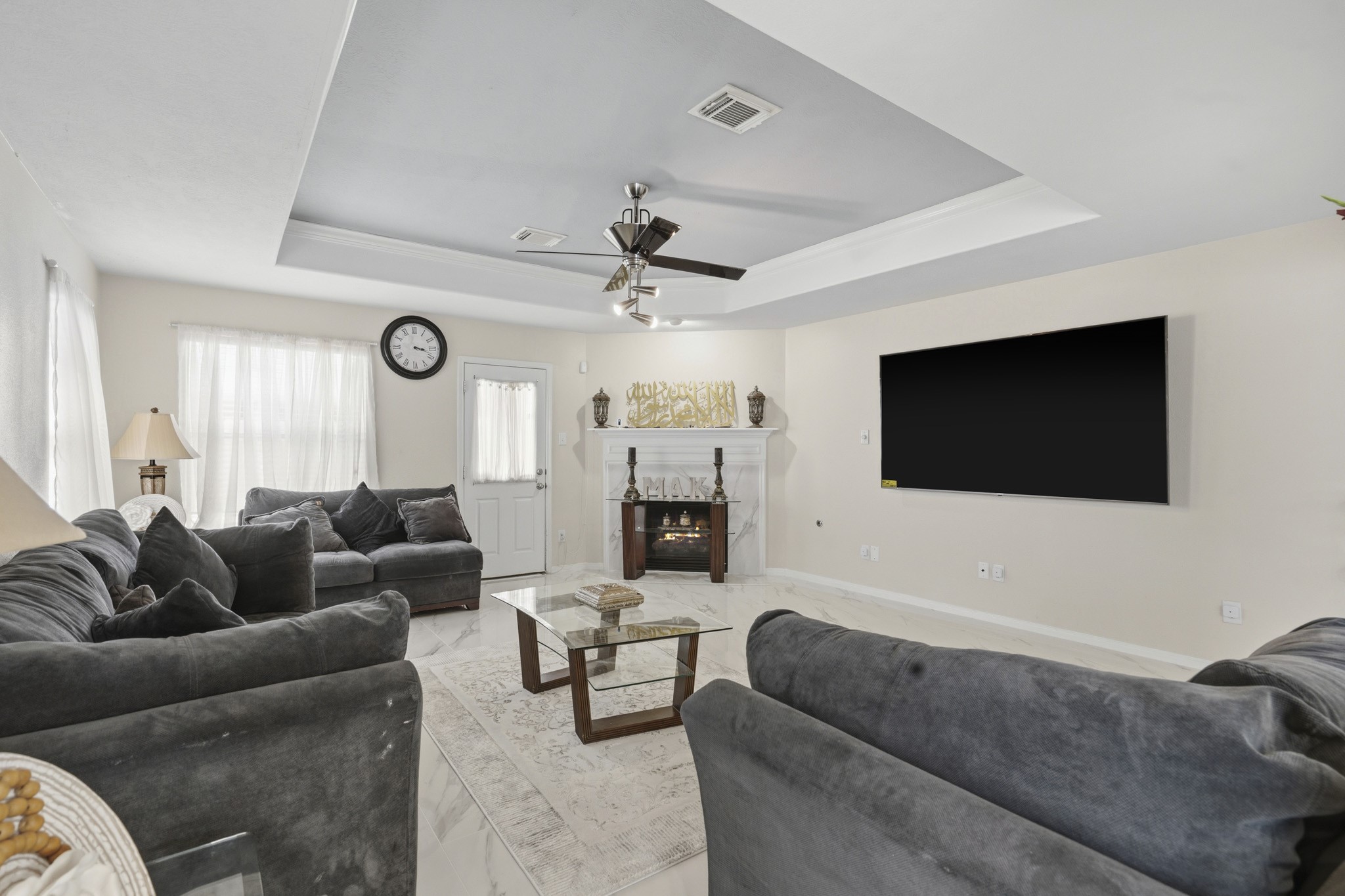 The spacious family room offers plenty of room to relax and gather, while the recessed ceiling and open layout add an airy feel.