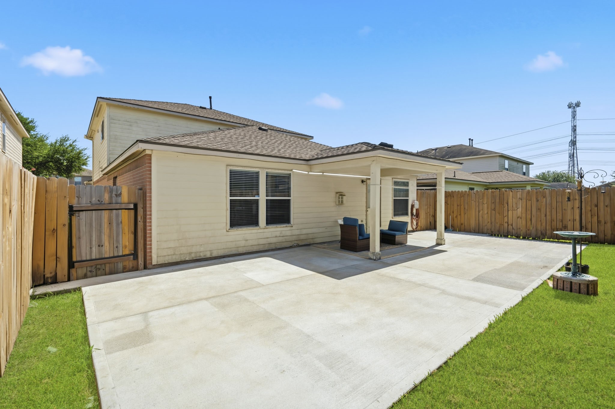 The fenced backyard pairs a large patio with manageable lawn space, creating an easy setting for outdoor fun and relaxation.