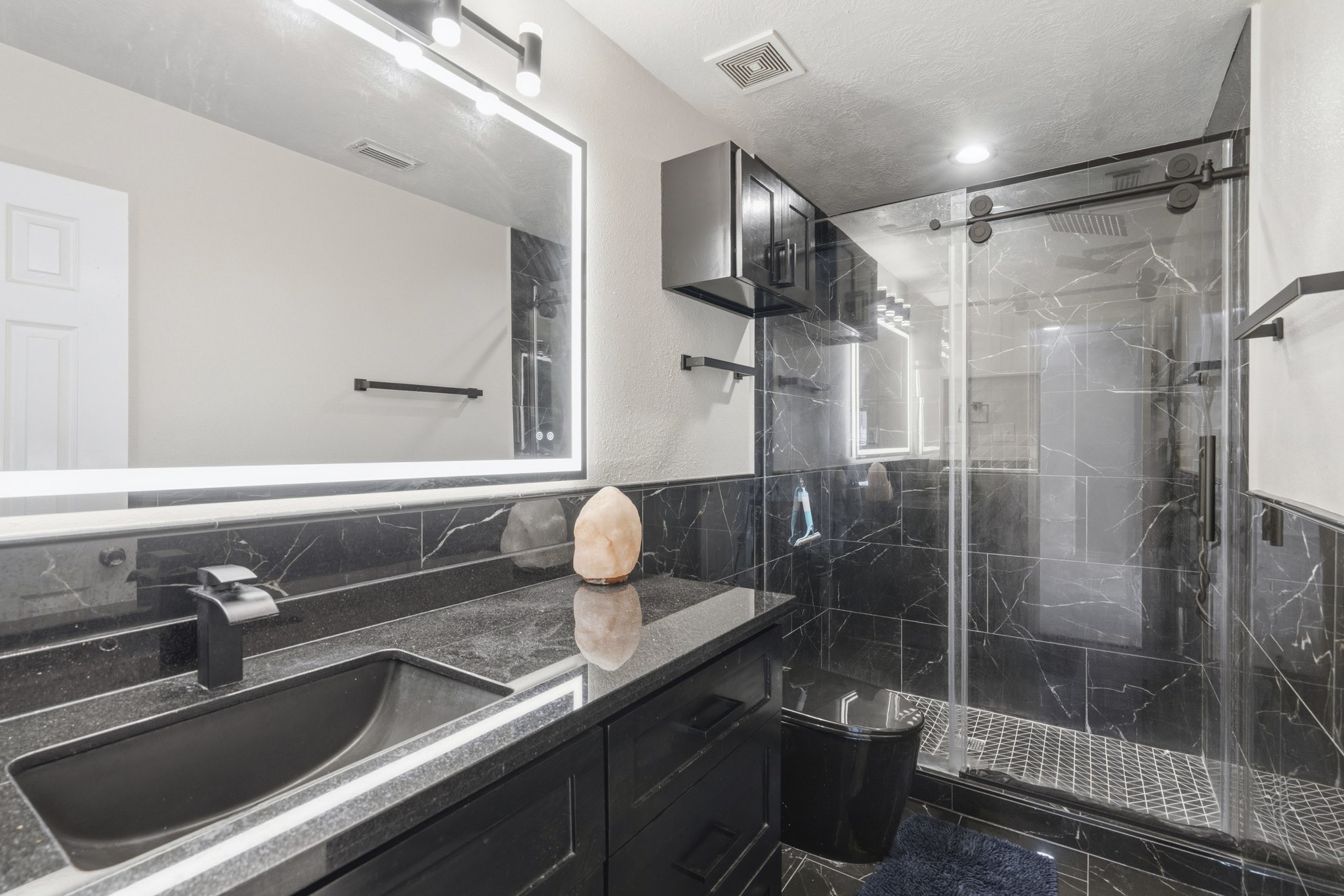 Completely remodeled, the upstairs bathroom offers a sleek vanity and a glass-enclosed walk-in shower.
