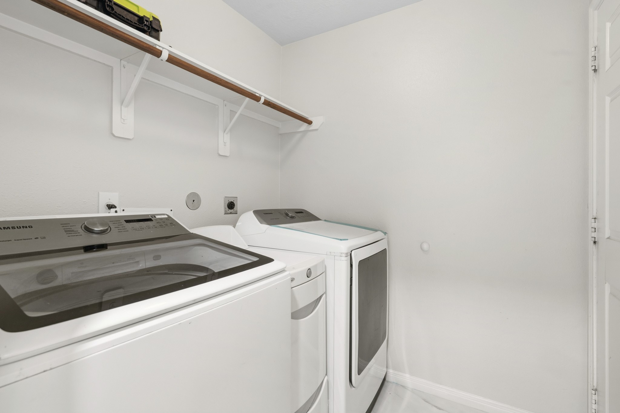 The convenient indoor utility room provides space for a full-size washer and dryer, along with shelving for laundry supplies.