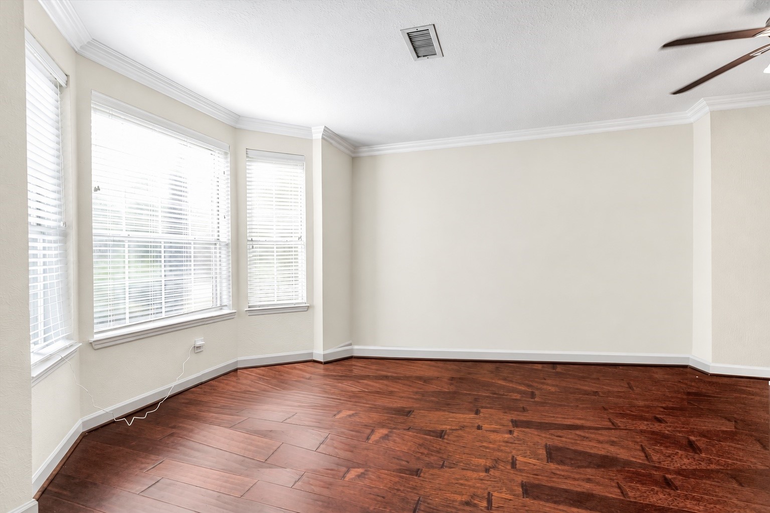 Bright and inviting room with rich wood flooring, large windows for natural light, and elegant crown molding. It is a flex area located at the front and can be used as an office or formal living. Bright and inviting room with rich wood flooring, large windows for natural light, and elegant crown molding. It is a flex area located at the front and can be used as an office or formal living.