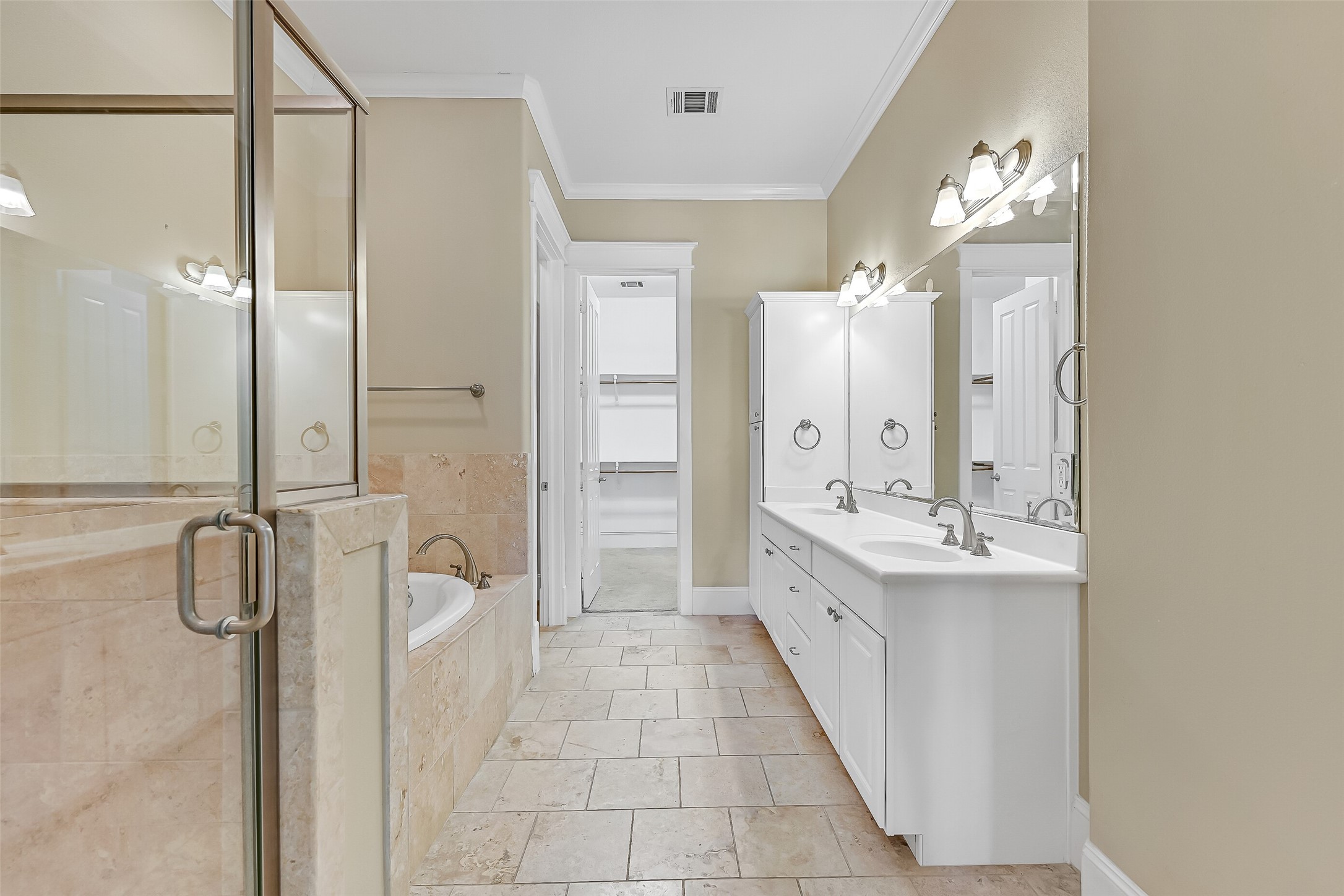 Primary bath lathed in travertine finishes.