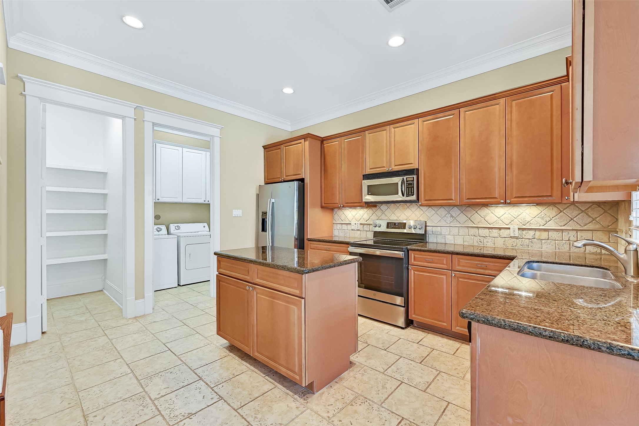 Updated kitchen with ample maple cabinetry. Walk-in pantry is to the left, while the door on the Right accesses the laundry & garage.