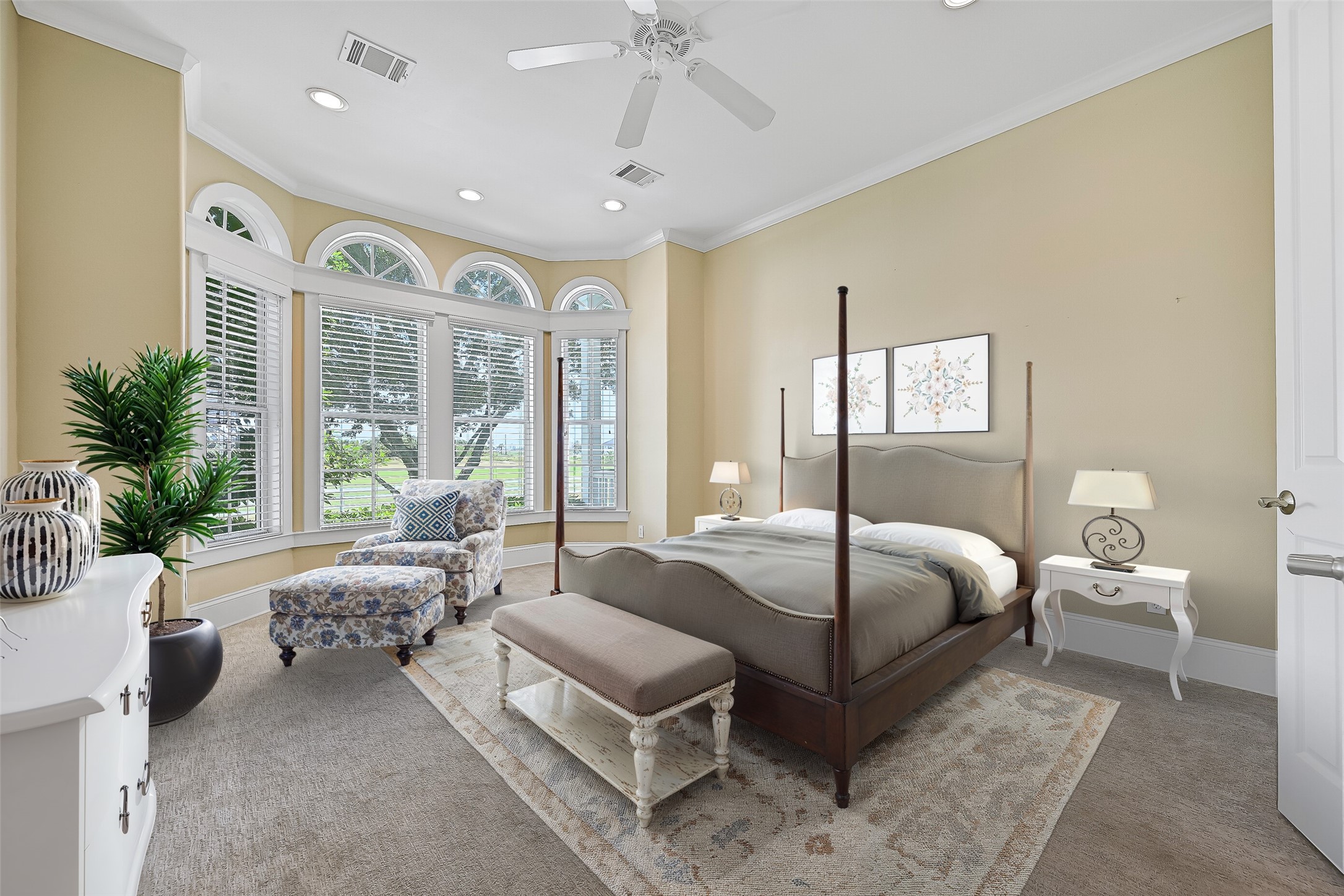 Welcome to the light and airy Primary en-suite with plush carpeting and rows of windows allowing in so much natural light and views of the golf course. This photo is virtually-staged.
