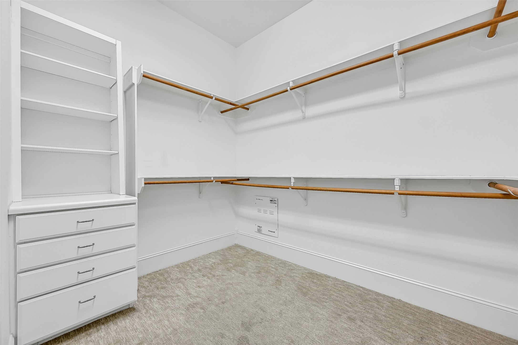 Cavernous walk-in closet featuring clever built-ins.