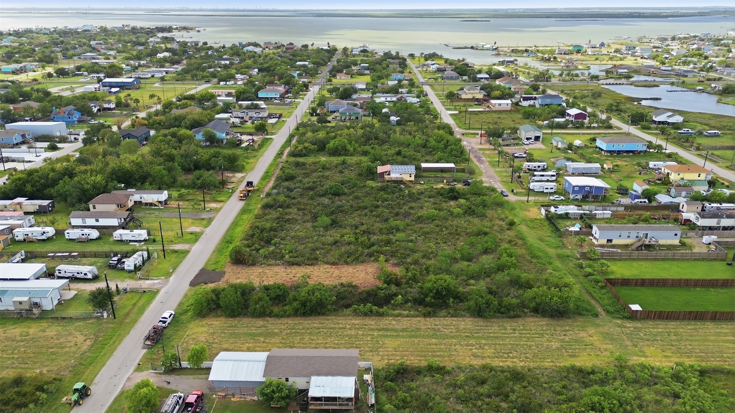 Looking straight down the paved 17th street toward the water. Tidal inlets are visible on the right, and the open lot is in the center of the frame.