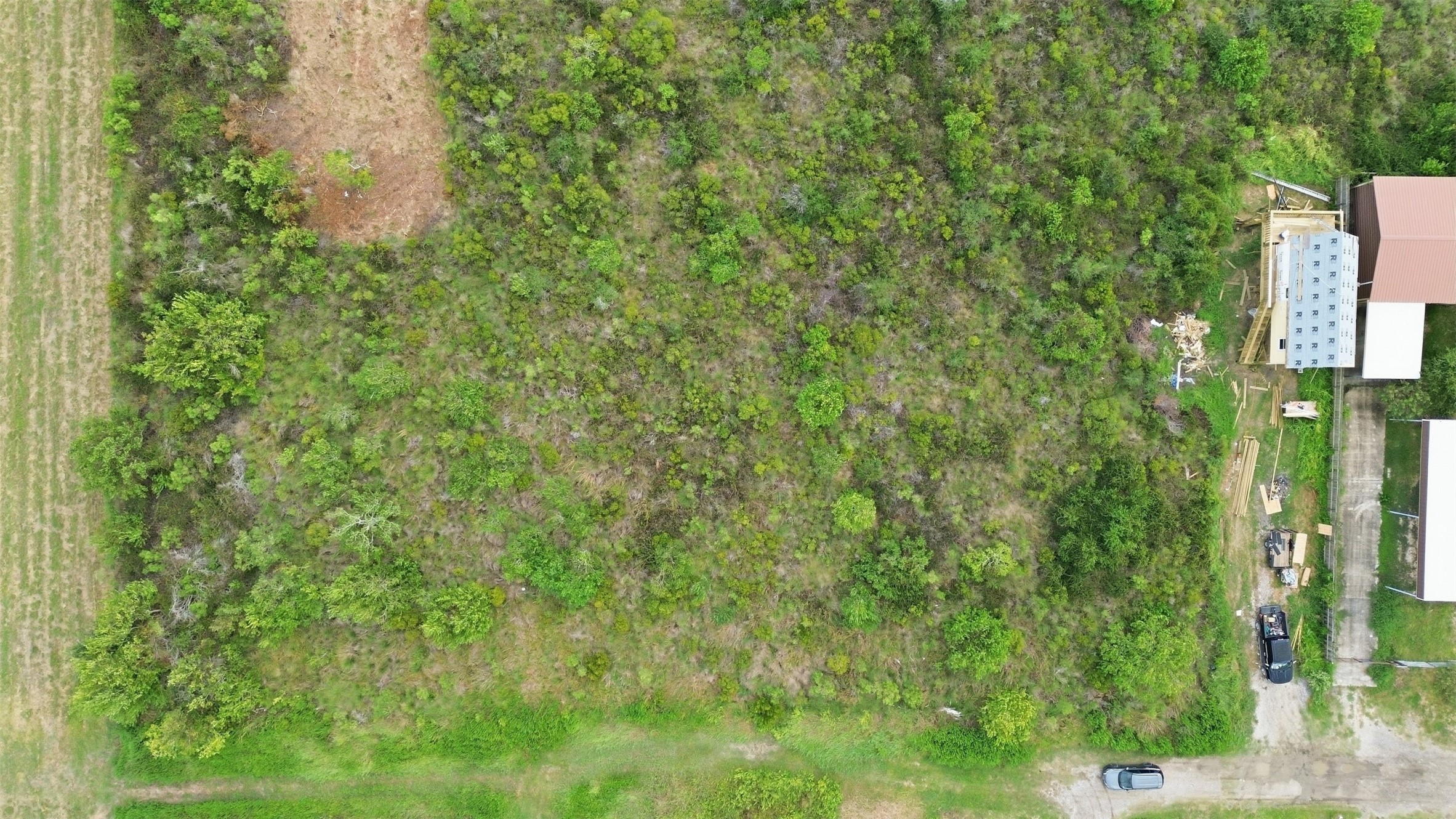 Directly overhead view of the tract, showing its overall shape and natural vegetation. The cleared area at the top of the frame is easy to see.