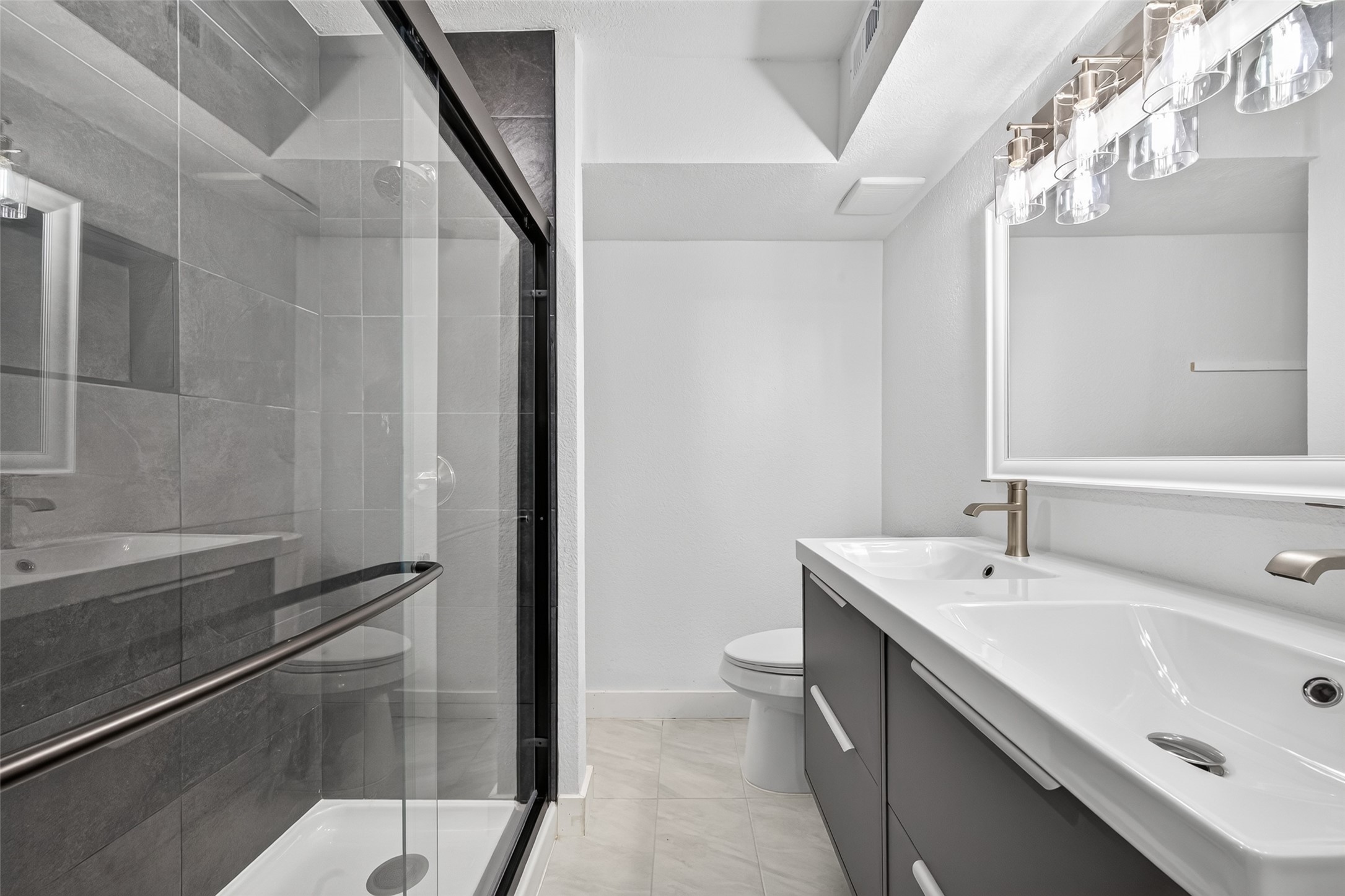 Contemporary vanity with double sinks, streamlined cabinetry, and carefully coordinated fixtures creates a fresh, polished bathroom retreat.