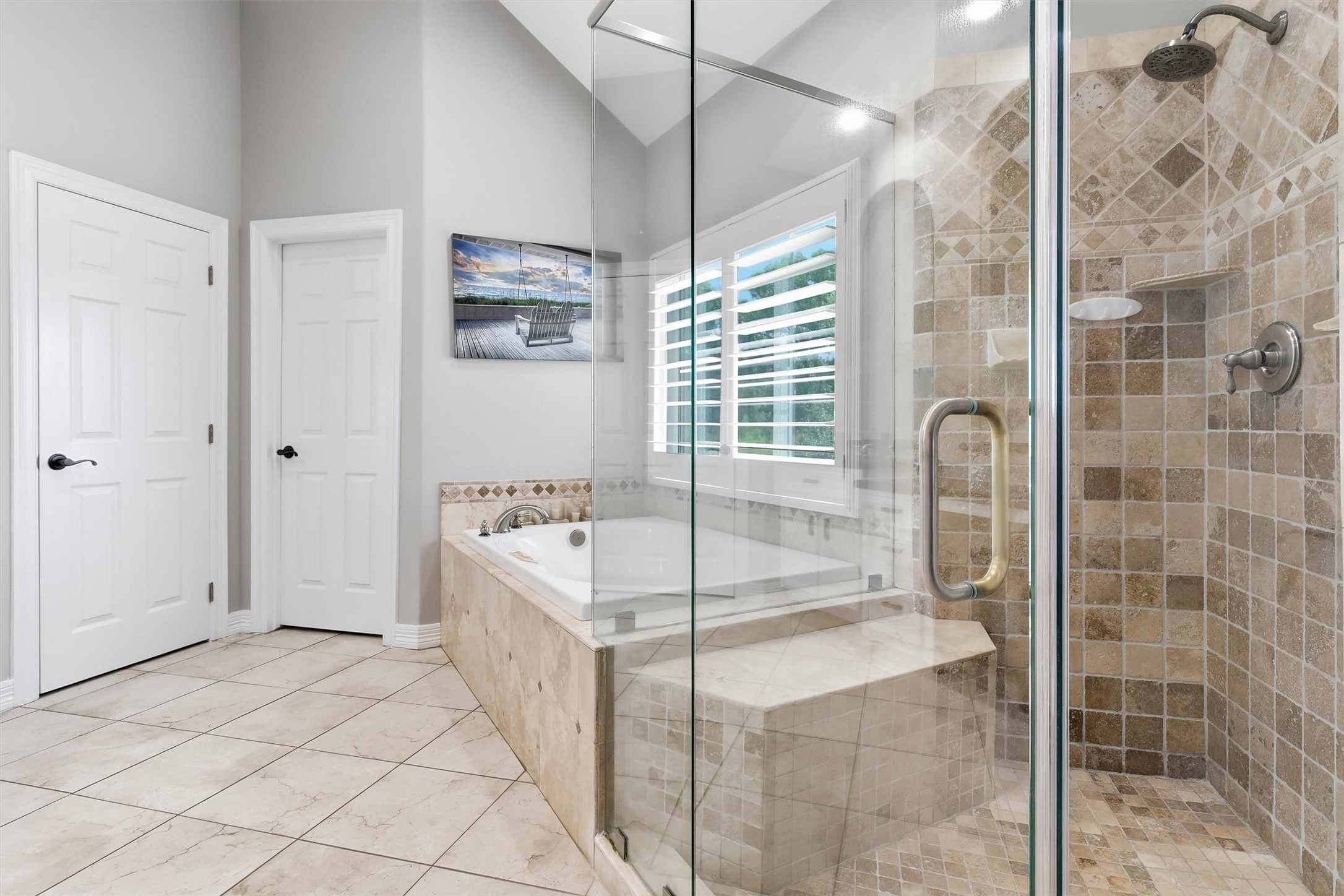 Relax in the deep soaking tub or the tiled walk-in shower, both accented with elegant stonework and a private window for natural light. This luxurious primary bath is the perfect place to unwind.