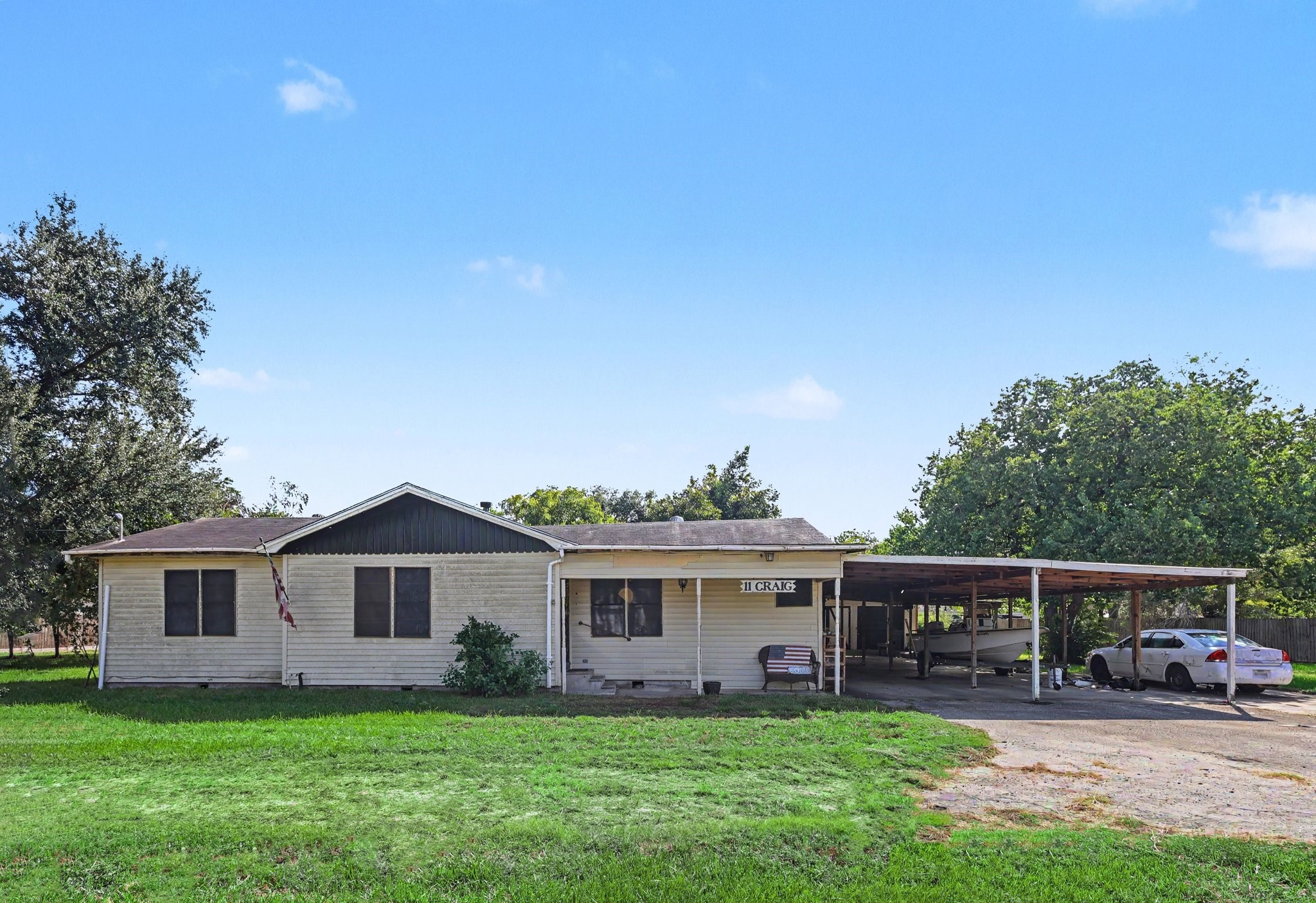 Front view featuring a covered porch, spacious carport and large front yard