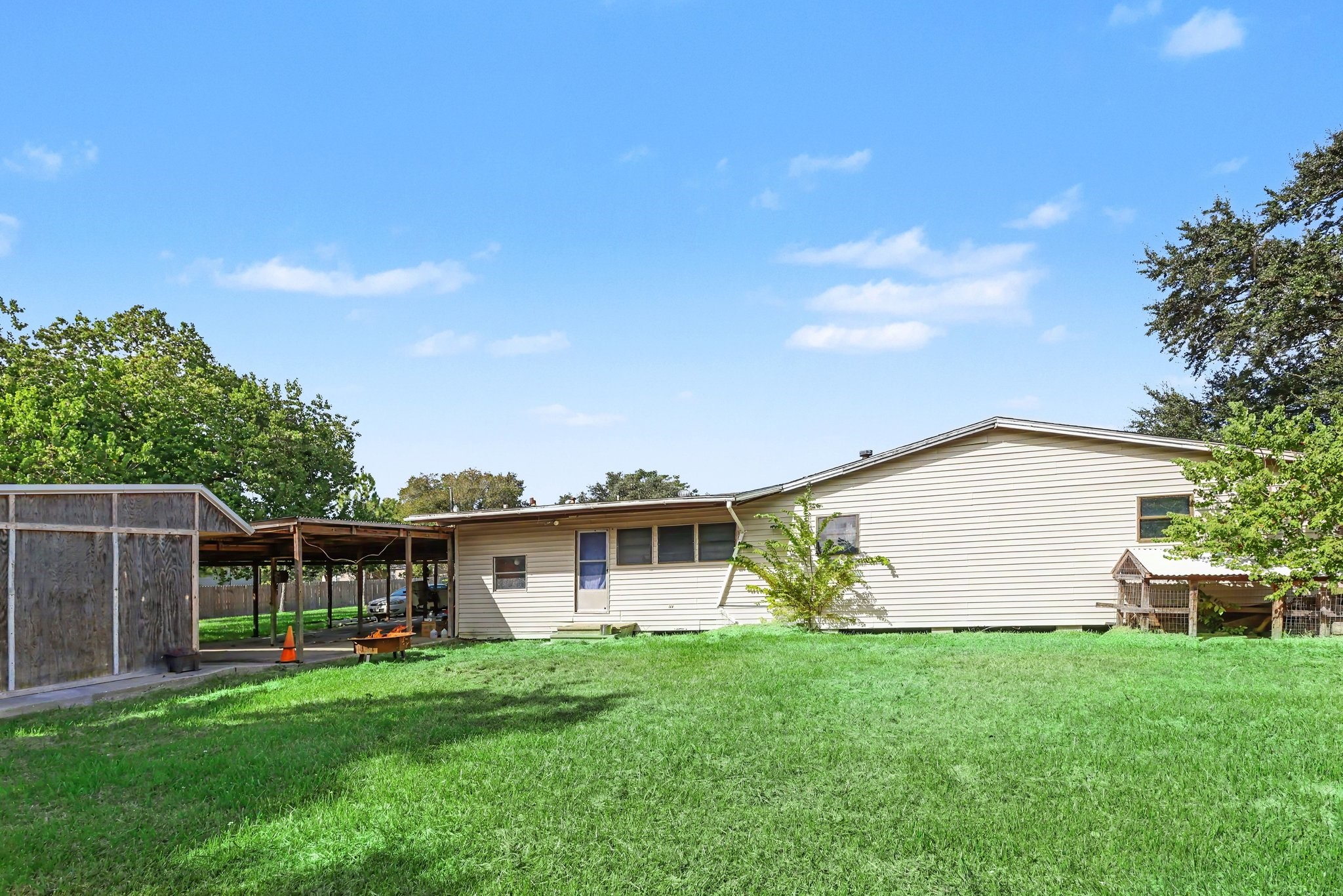 Spacious backyard with mature trees, a covered patio and ample room for outdoor activities