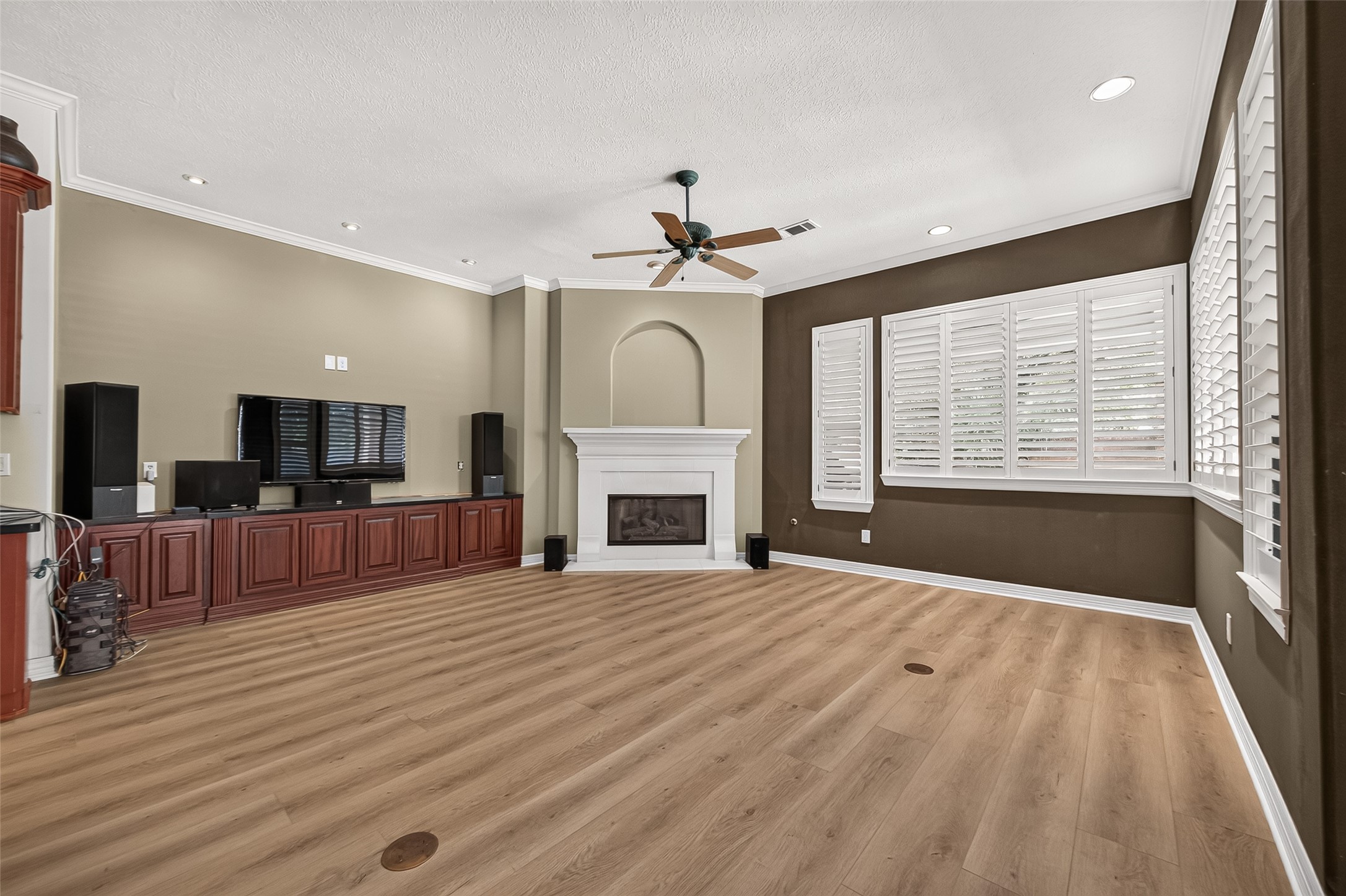 Spacious living room featuring a cozy fireplace, beautiful built-ins and abundant natural light.