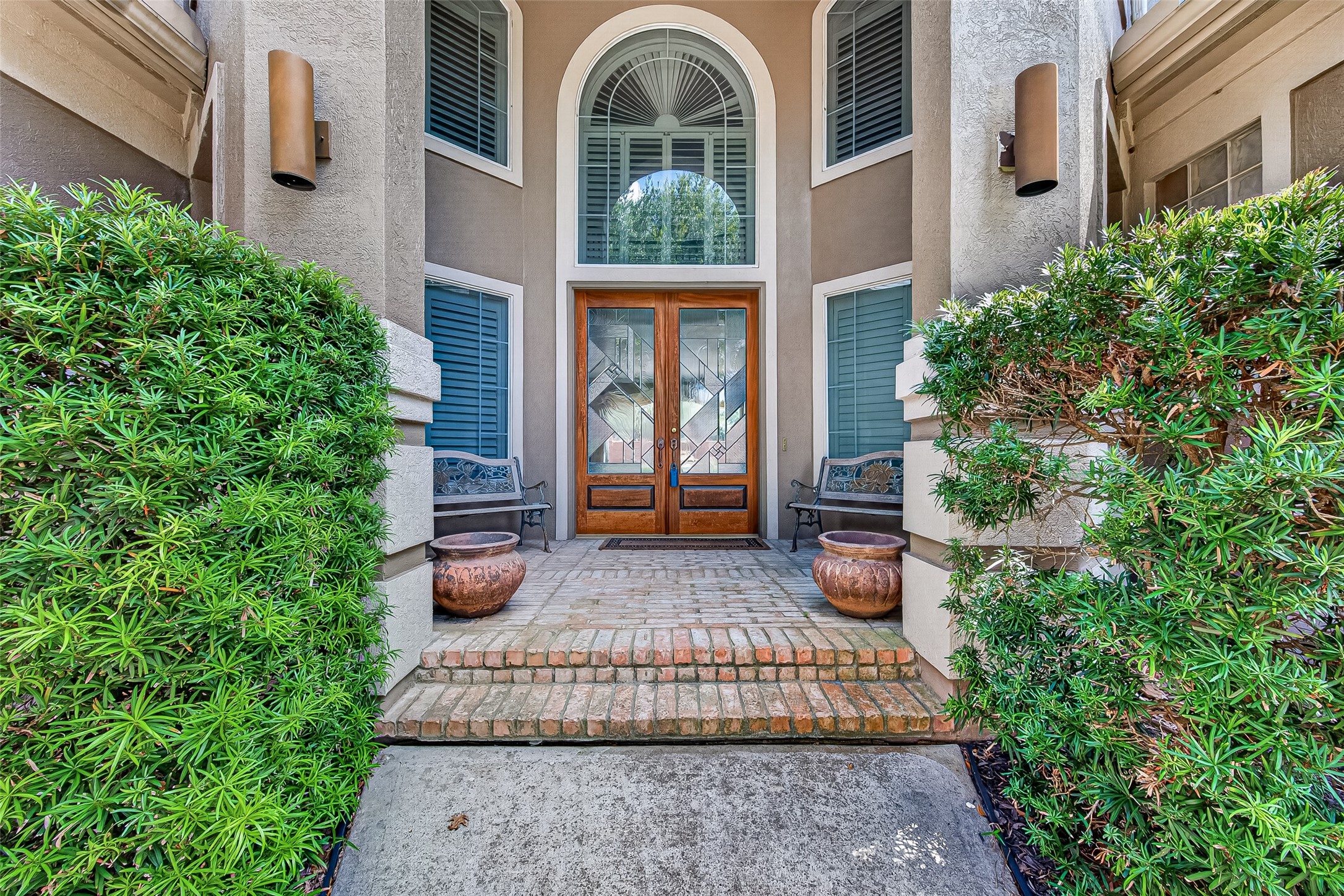 Elegant entryway featuring double French doors and a welcoming front porch.