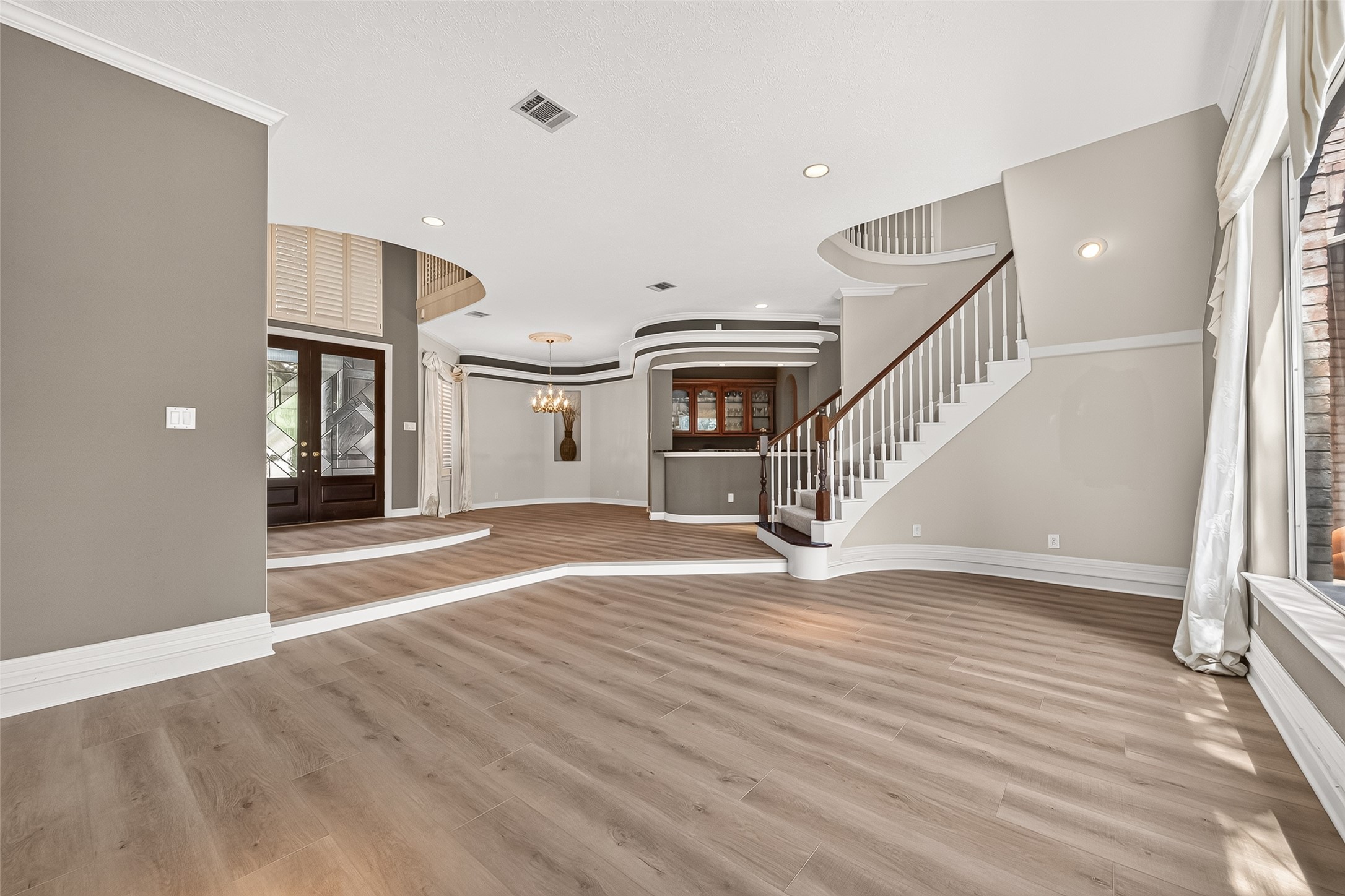 Another look at this amazing entryway with a seamless flow of the formal dining, sitting area, and wet bar for you to entertain effortlessly.