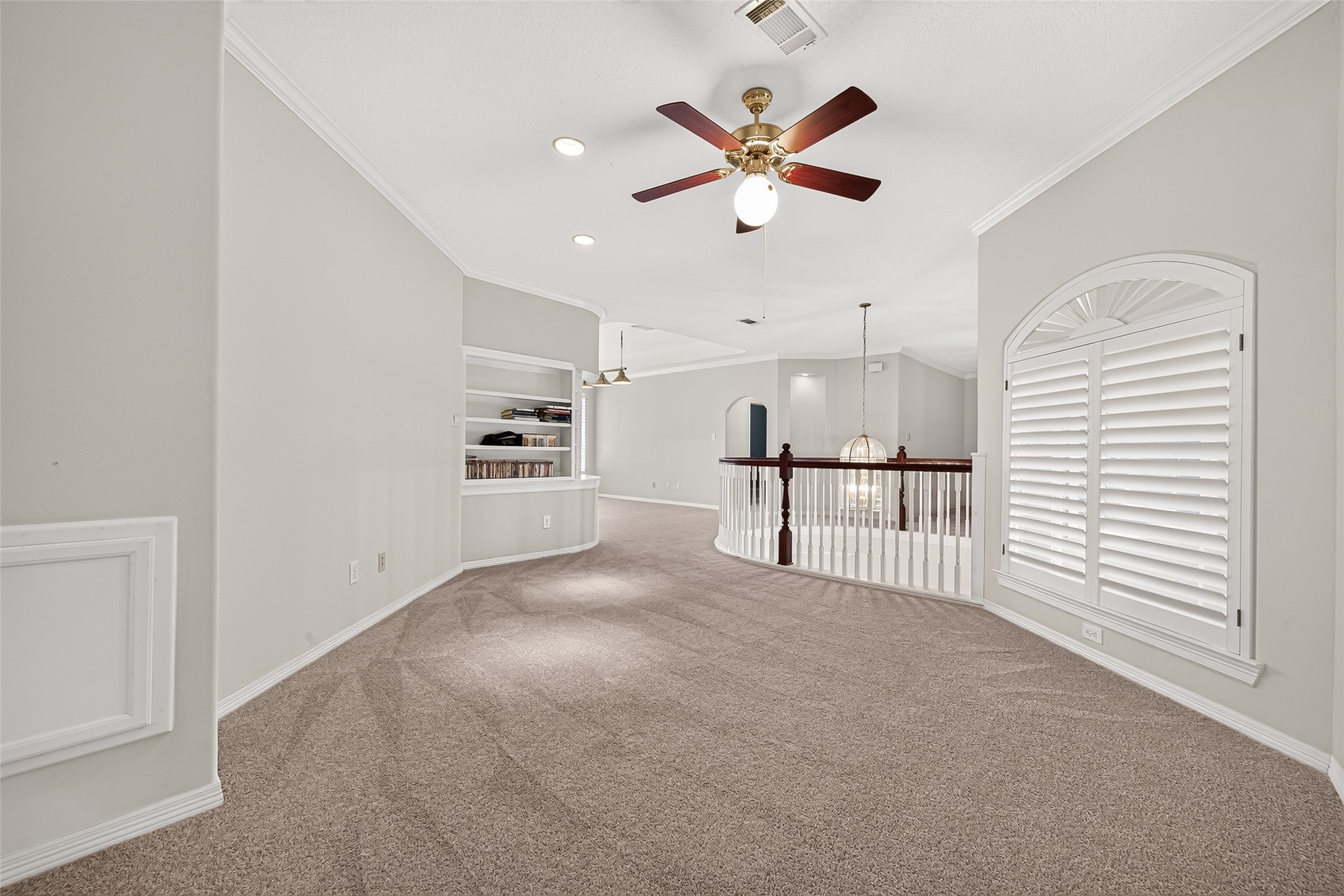 Spacious flex space featuring built-in shelving and elegant railing overlooking the staircase that can be used as an open office or customized to fit your needs