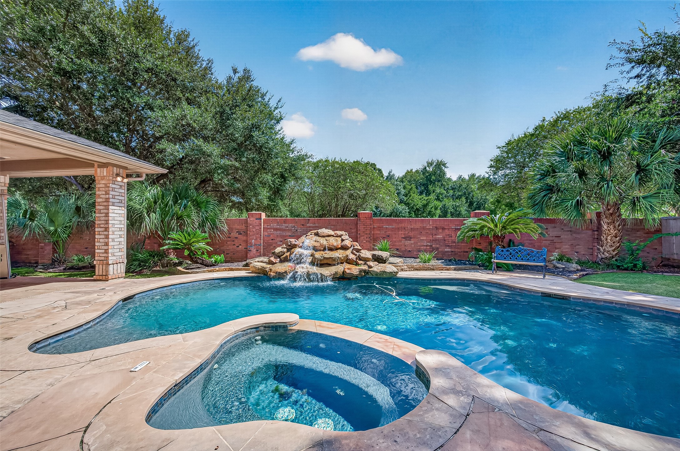 Experience luxury in this backyard oasis featuring a sparkling pool/spa with a waterfall, surrounded by lush landscaping and an extended covered patio