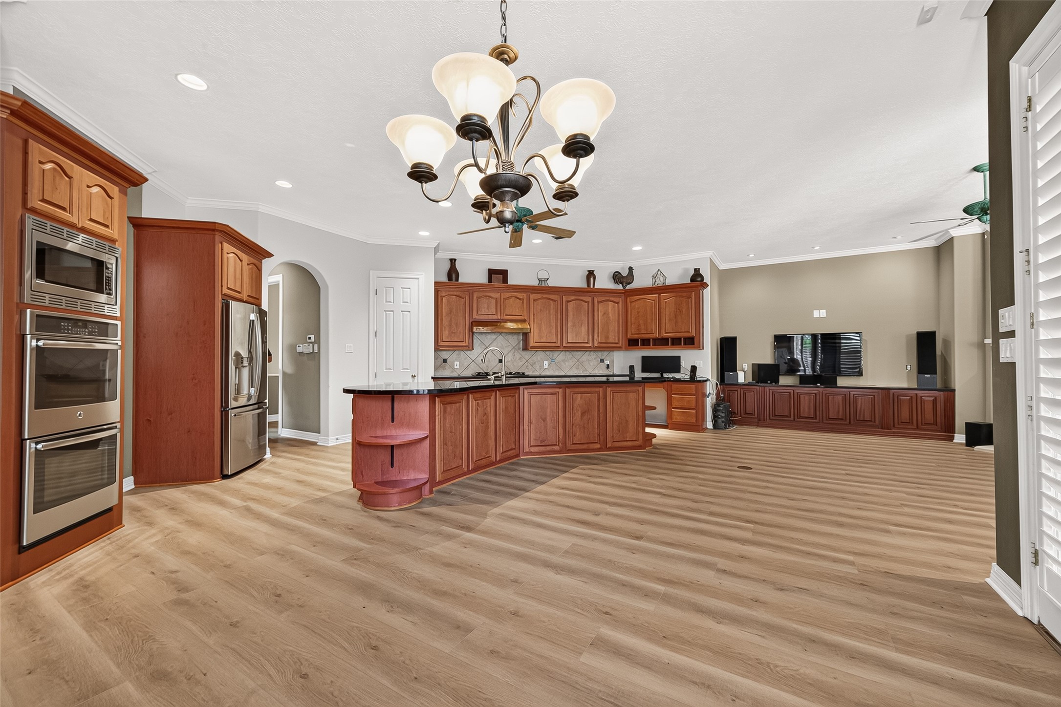 Spacious open-concept kitchen and living area featuring rich wood cabinetry, stainless steel appliances, and plenty of counter and cabinet space.