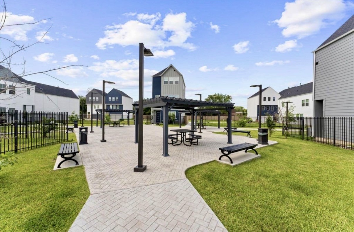 Community park with pergolas, picnic tables, benches, and green space, just steps from home.