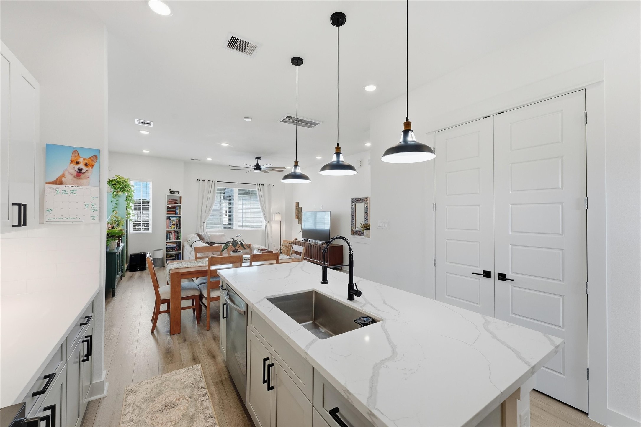 Open-concept layout with a double-door pantry just off the island.