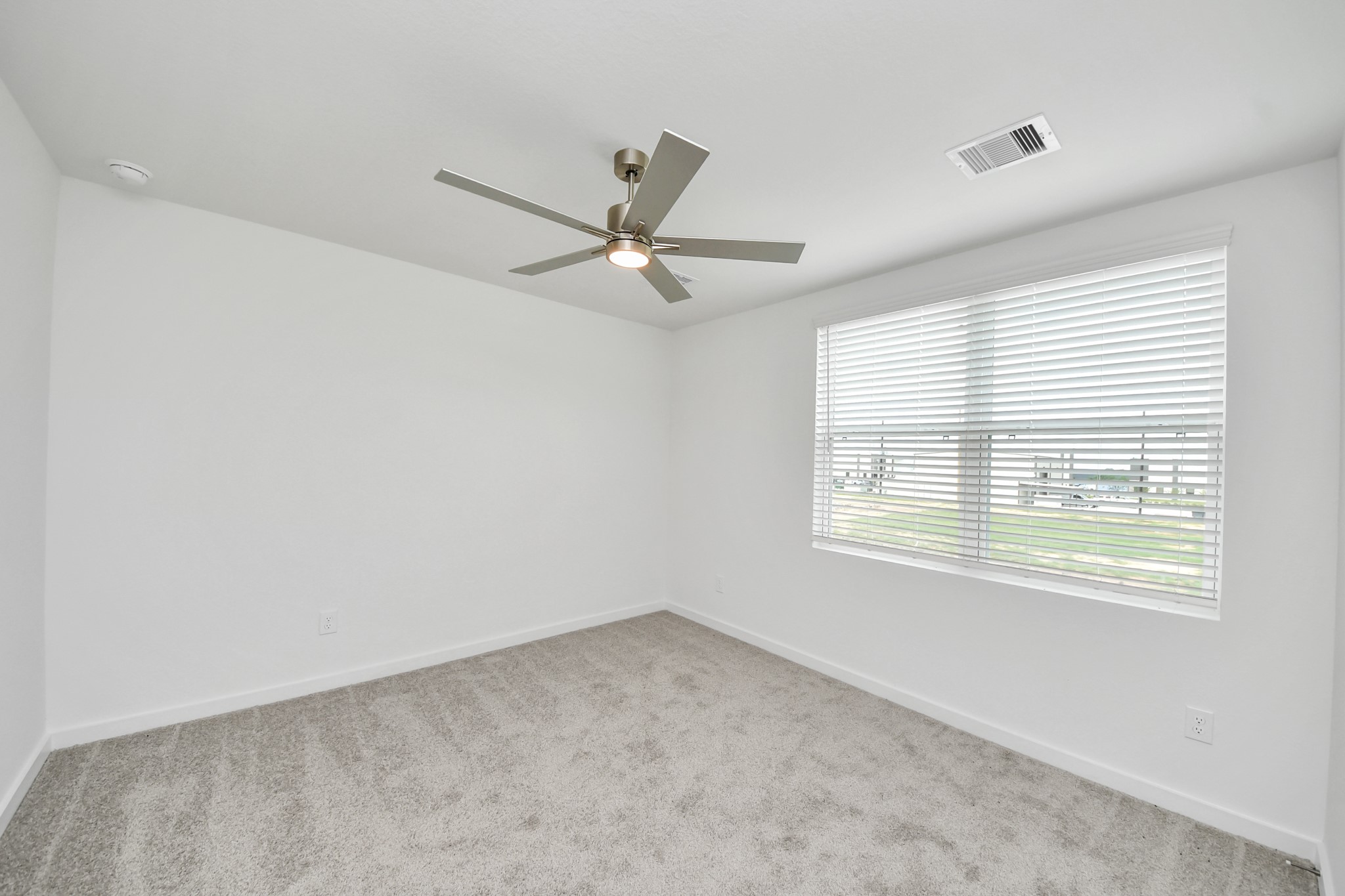 Secondary bedroom features plush carpeting, large windows that let in plenty of natural light, bright paint, and spacious closets. Sample photo of completed home with similar floor plan. Actual colors and selections may vary.