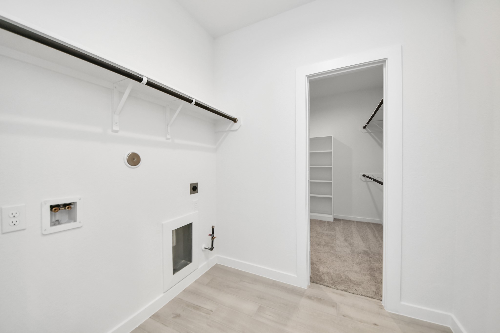 A perfect blend of functionality and comfort. Capture the essence of easy living with a first-floor laundry room, thoughtfully equipped with shelving for effortless organization. Both electric and gas connections available. Sample photo of completed home with similar floor plan. Actual colors and selections may vary.