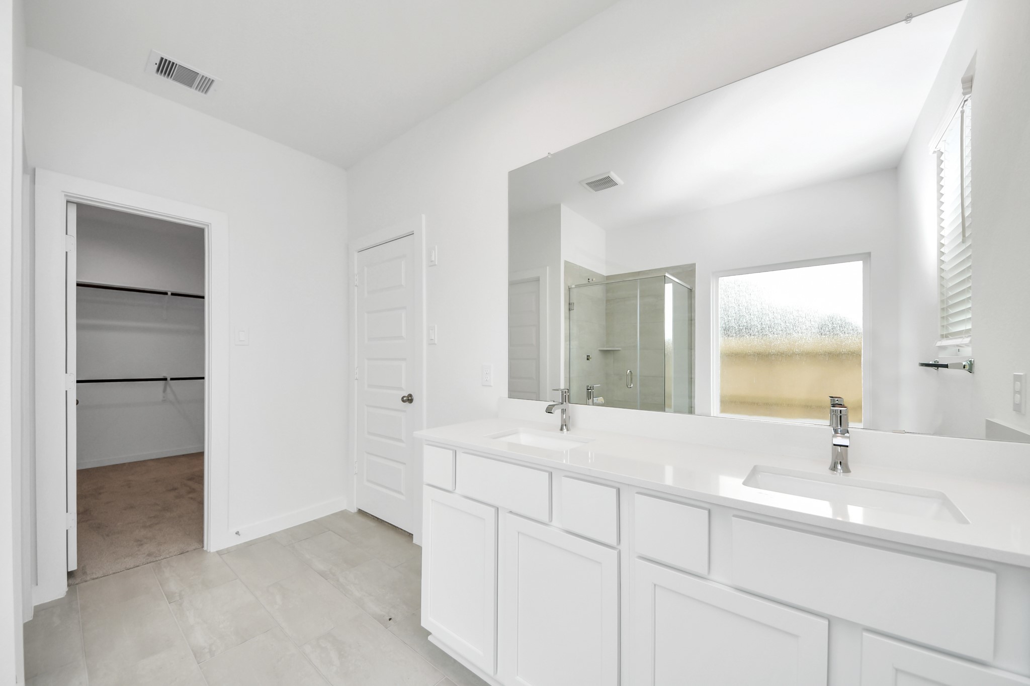 Elevate your daily routine at the elegant vanity, now equipped with double sinks, light countertops, modern hardware, and beautiful recessed lights. Sample photo of completed home with similar floor plan. Actual colors and selections may vary.