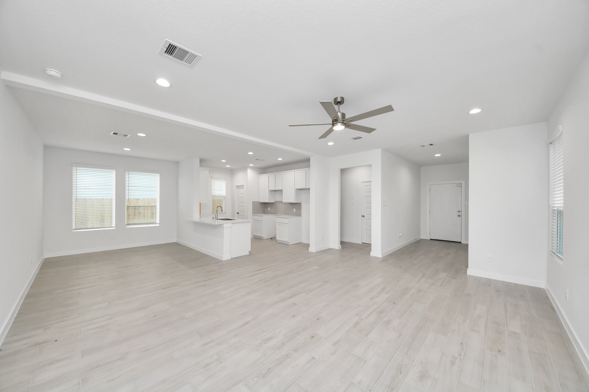 Gather the family and guests together in your lovely living room! Featuring soaring high ceilings, recessed lighting, ceiling fan, custom paint, gorgeous floors, and large windows that provide plenty of natural lighting throughout the day. Sample photo of completed home with similar floor plan. Actual colors and selections may vary.