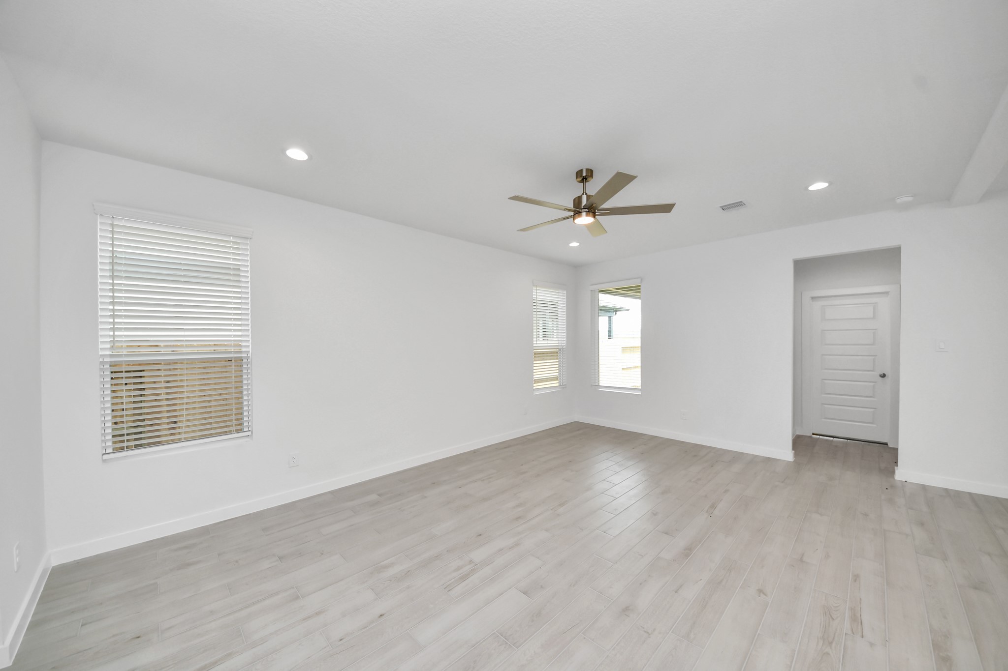 Family room flooded with natural light through the expansive windows.  The premium tile flooring adds a touch of luxury to the space, creating the perfect setting for relaxing moments and cherished gatherings with loved ones. Sample photo of completed home with similar floor plan. Actual colors and selections may vary.