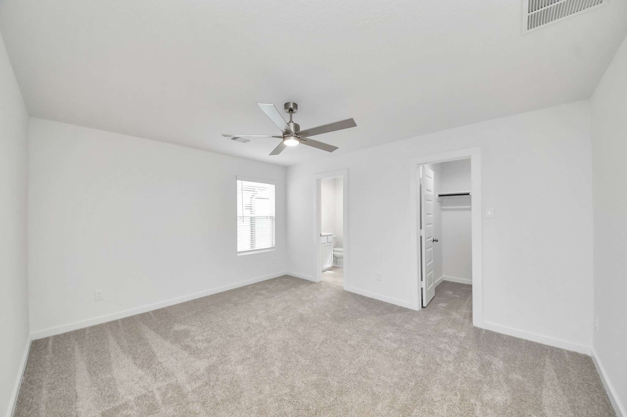 Secondary bedroom features plush carpeting, large windows that let in plenty of natural light, bright paint, and spacious closets. Sample photo of completed home with similar floor plan. Actual colors and selections may vary.
