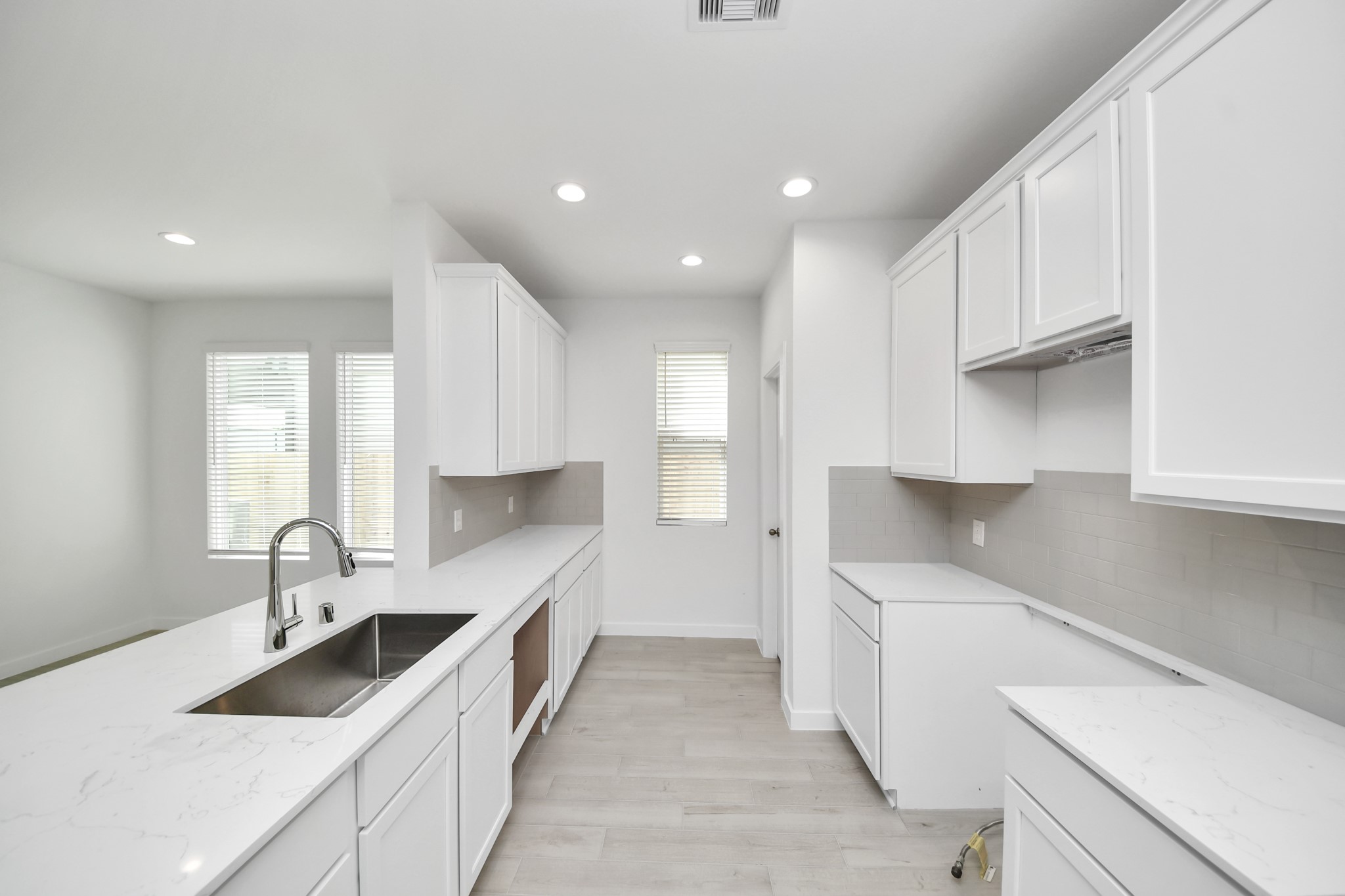 Culinary haven, featuring granite countertops, a tile backsplash, stainless steel appliances (to be installed), and 42 upper cabinets. Sample photo of completed home with similar floor plan. Actual colors and selections may vary.