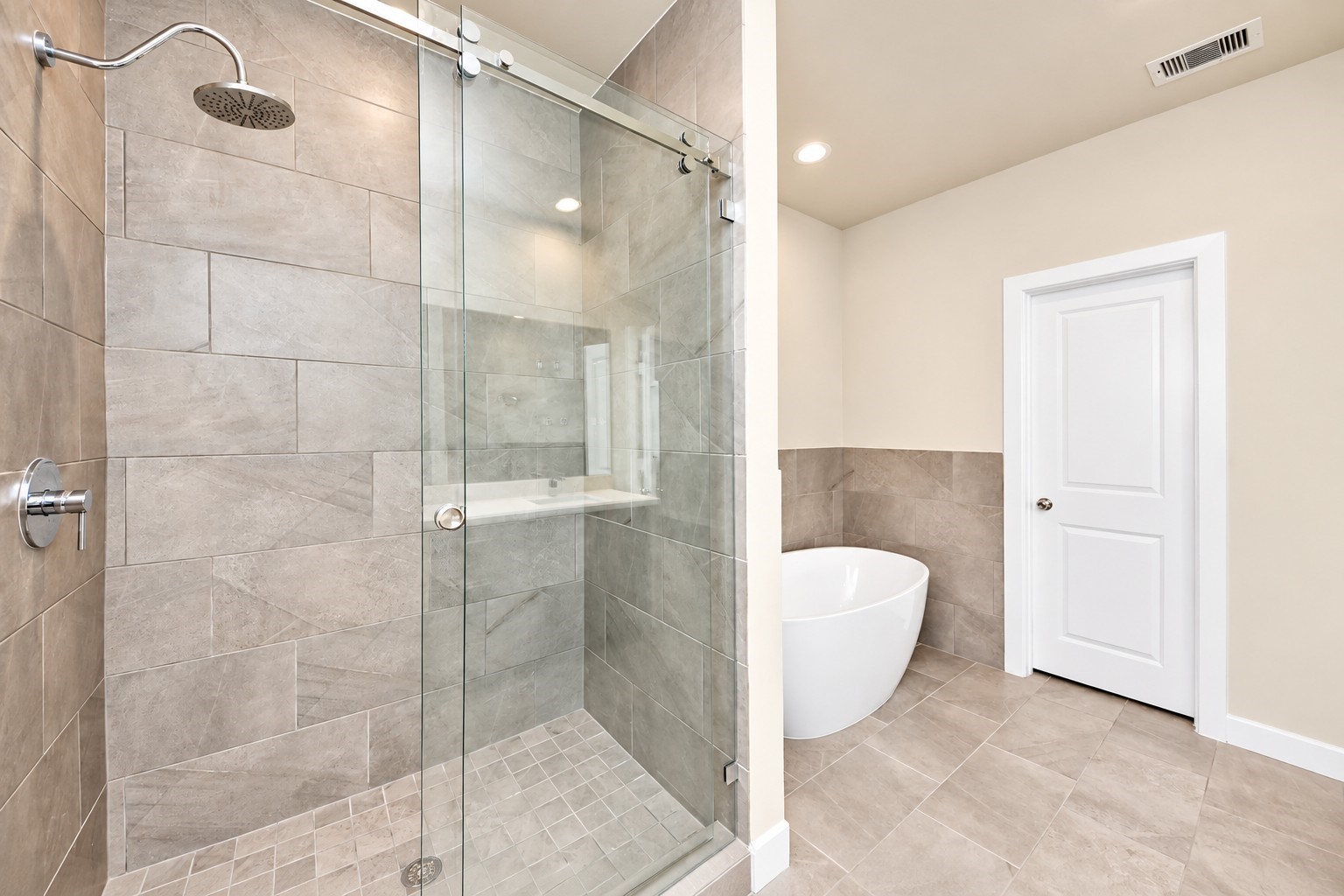 Primary bathroom with glass shower and free-standing tub.