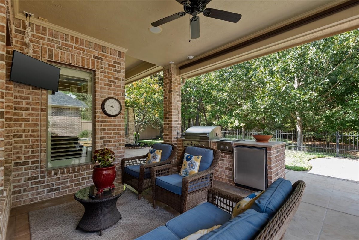Covered patio has a TV and grill, gas burner and fridge- perfect for backyard entertaining.