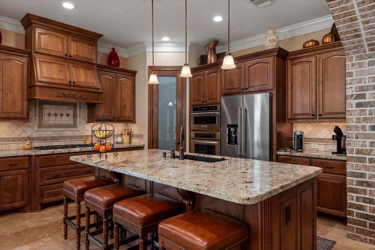 The island adds extra seating for guests in the kitchen. Elegant pendant lighting illuminate the island workspace.