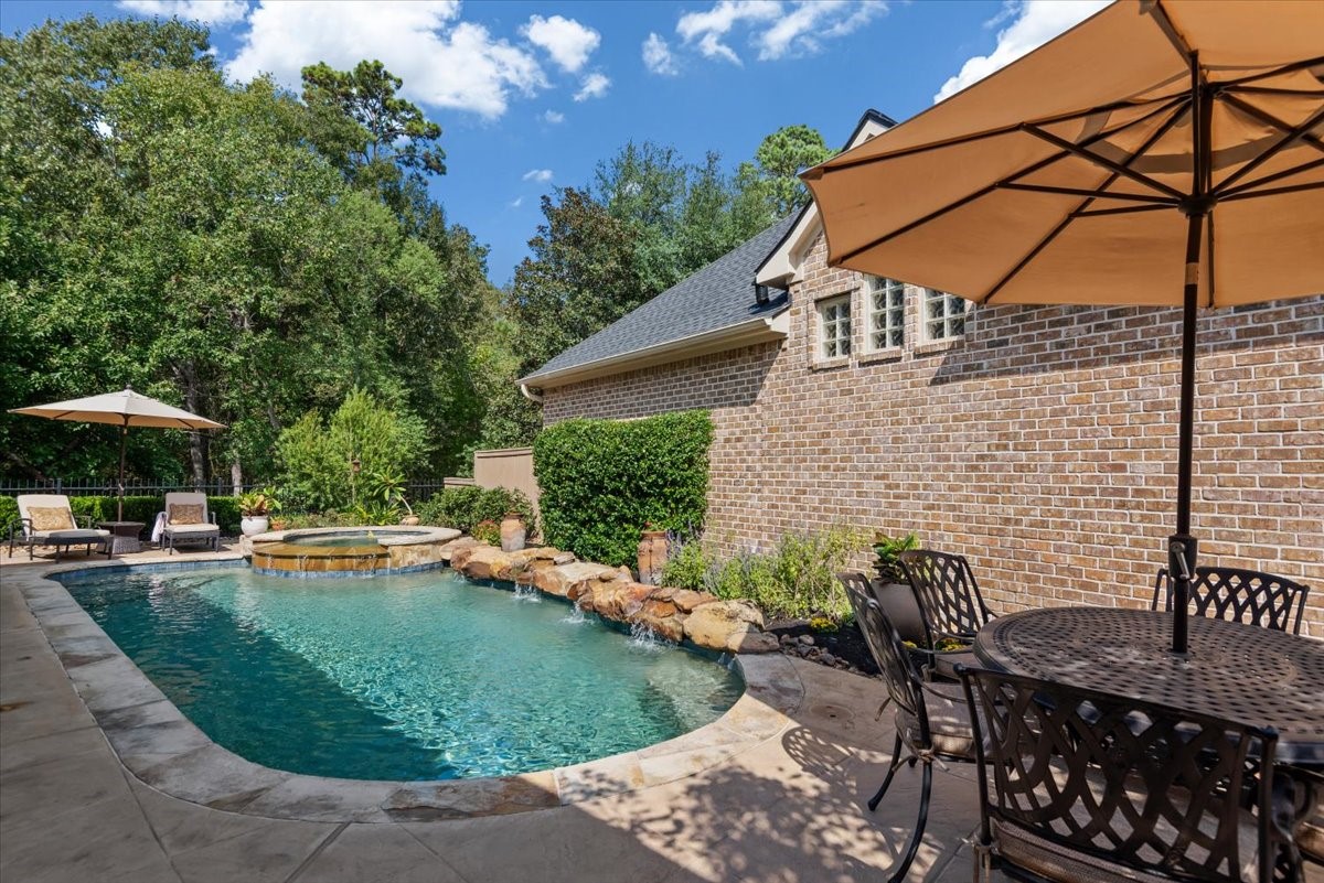 Refreshing pool and spa features rock waterfalls, pebble tech finish, flagstone edge, and lush landscape.