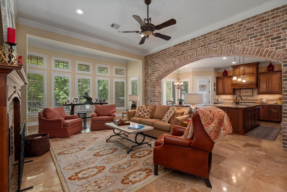 The main living room shares the beautiful brick archway and view of the lush landscape in the backyard.