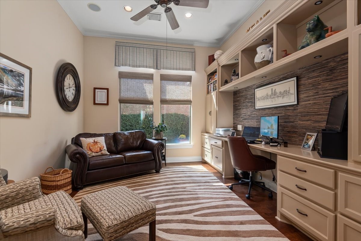 A wall of built-ins make this office extremely functional. Window shades and custom draperies frame the view to private garden courtyard.