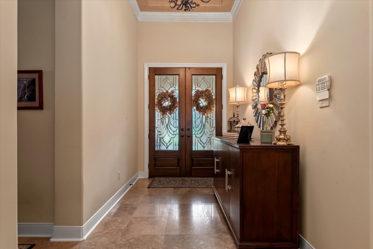 Travertine floors and tall ceilings extend into the main living areas.