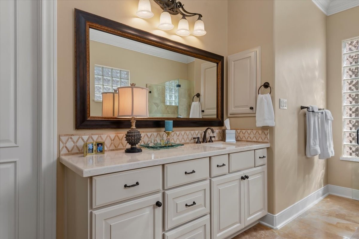Light marble counter tops and back splash compliment the honed travertine tile floor.