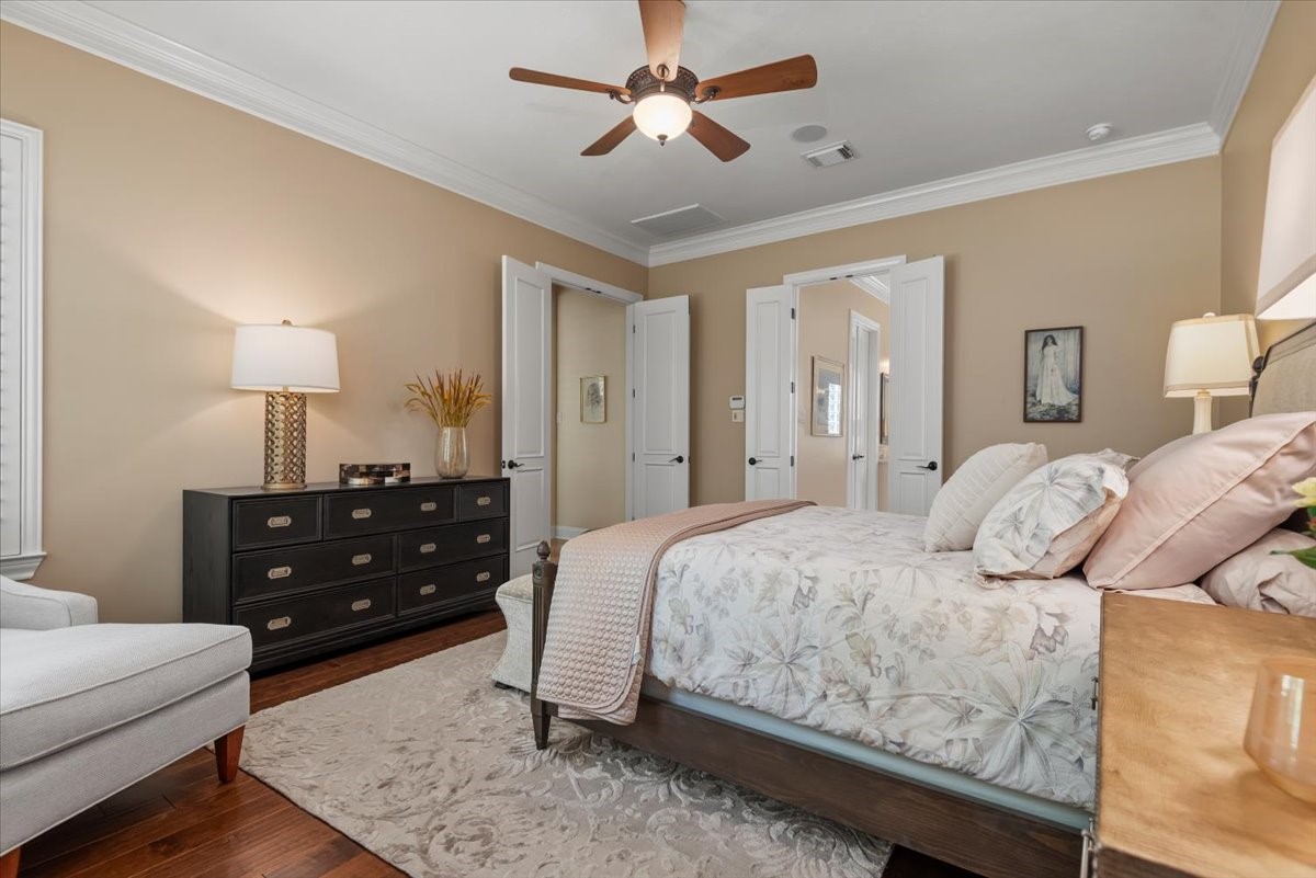 The primary bedroom has neutral walls and hardwood floors.